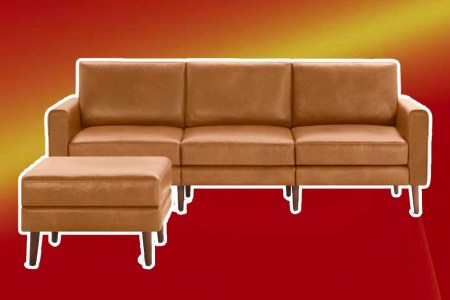 Burrow's leather Nomad sofa and ottoman on a red background