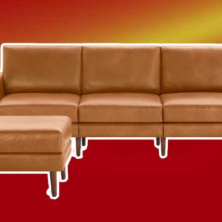 Burrow's leather Nomad sofa and ottoman on a red background