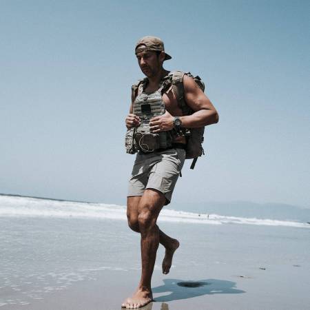 Kaj Larsen walks on the beach in Navy SEAL equipment.