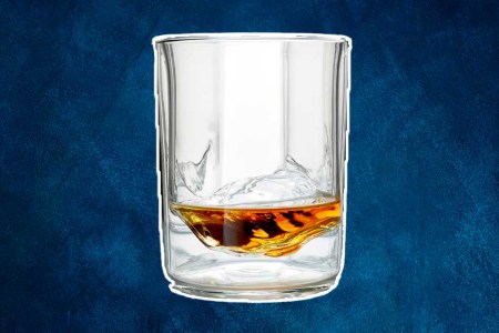 A Whiskey Peaks glass with booze in it. The glassware is on sale at Huckberry.