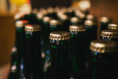 Dozens of bottles of beer with a focus on their bottle caps