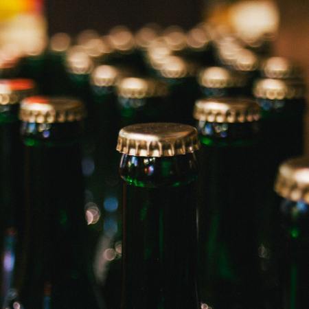 Dozens of bottles of beer with a focus on their bottle caps