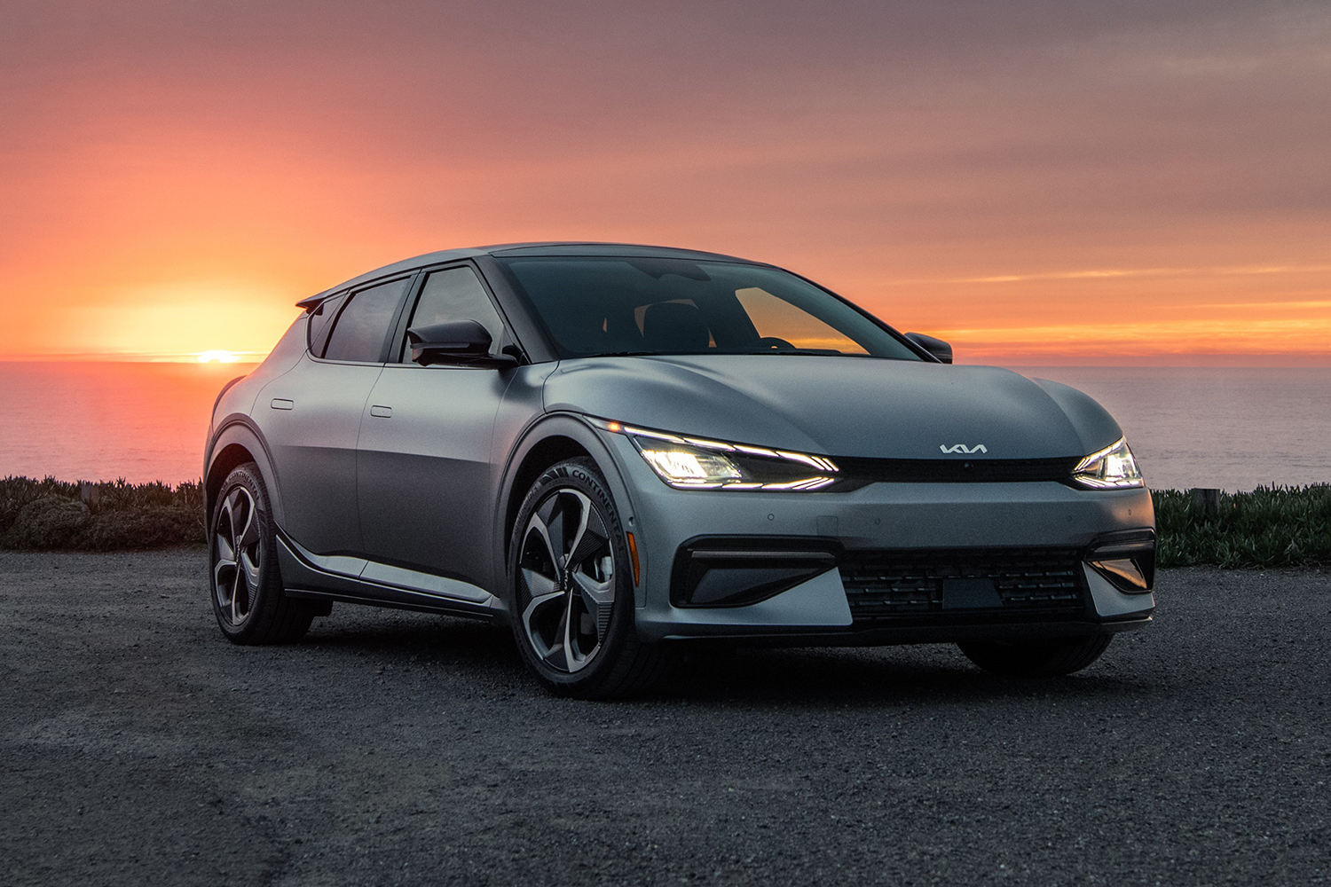 The 2022 Kia EV6, an electric SUV, sitting in front of a sunset