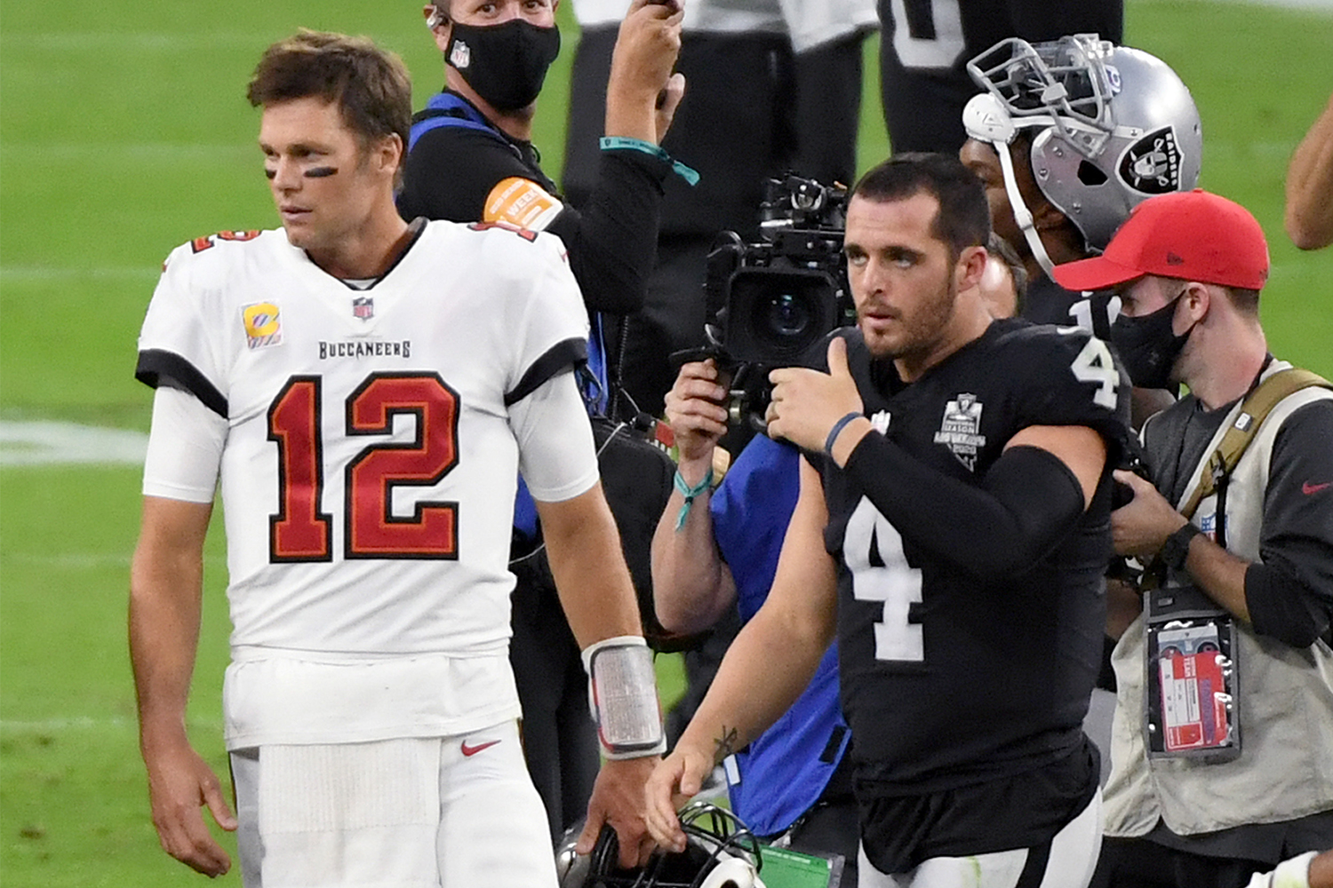 Tom Brady and Derek Carr walk off the field after a game at Allegiant Stadium in 2020 in Las Vegas.