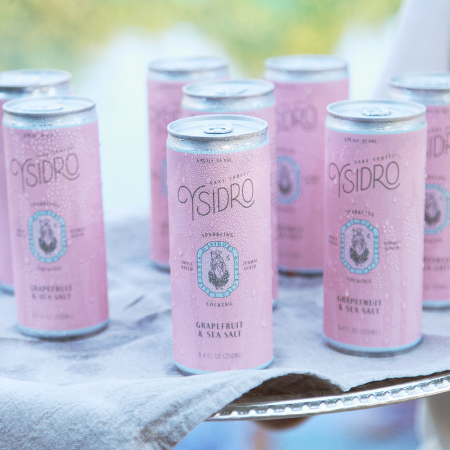 A server holding up a platter of Ysidro's sake spritz, a canned cocktail from Montecito