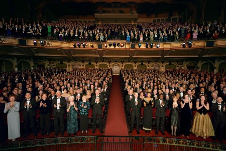 A crowd in a theater gives a standing ovation