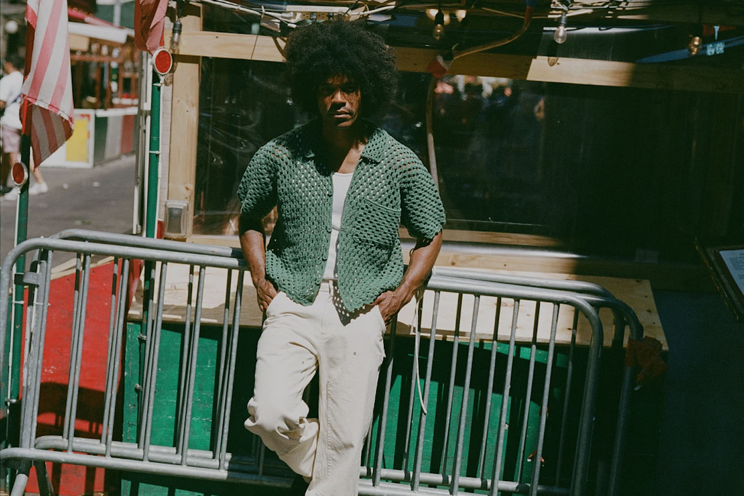 a model standing against a fence in No Maintenence clothing