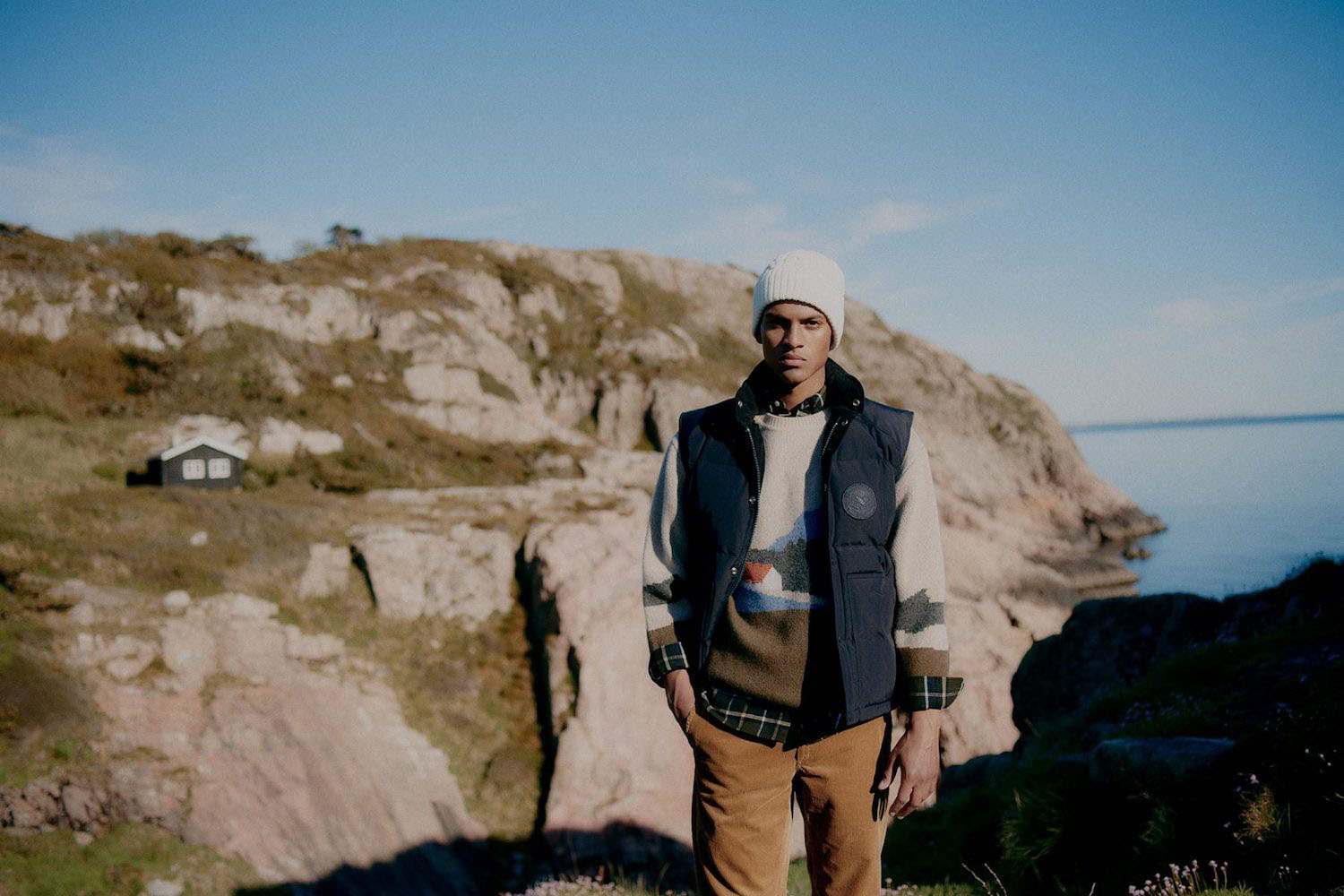 a model wearing Norse Porjects Clothing Standing on a ledge