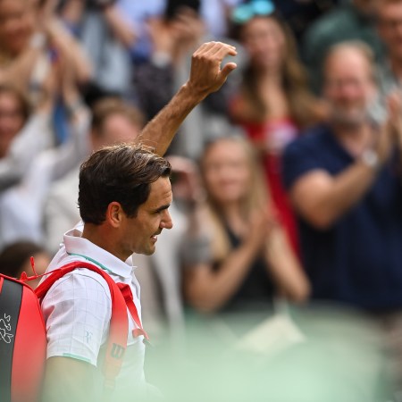 Roger Federer walks off the court at Wimbledon and waves to the crowd. He announced his retirement this week.