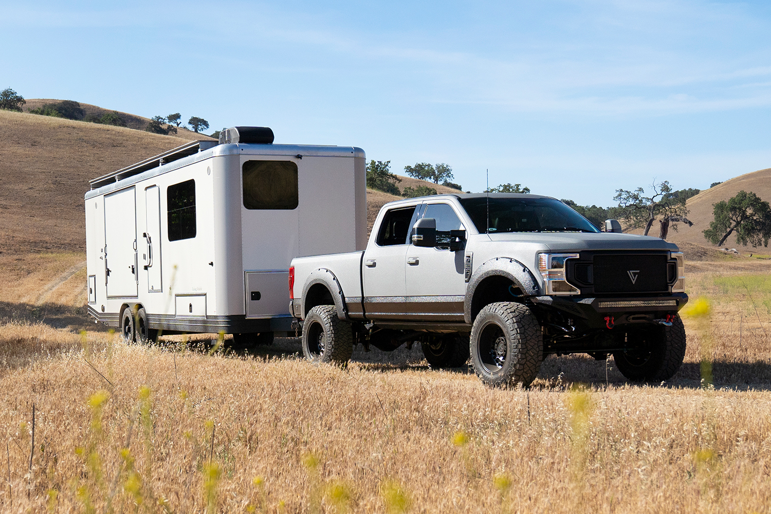 A pickup truck towing the 2023 Living Vehicle. We spoke with founder Matthew Hofmann about the luxury travel trailer.