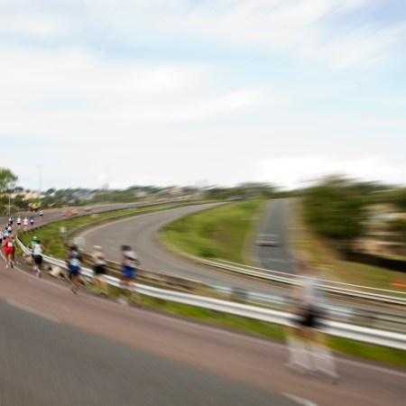 A group of runners racing along an empty street.