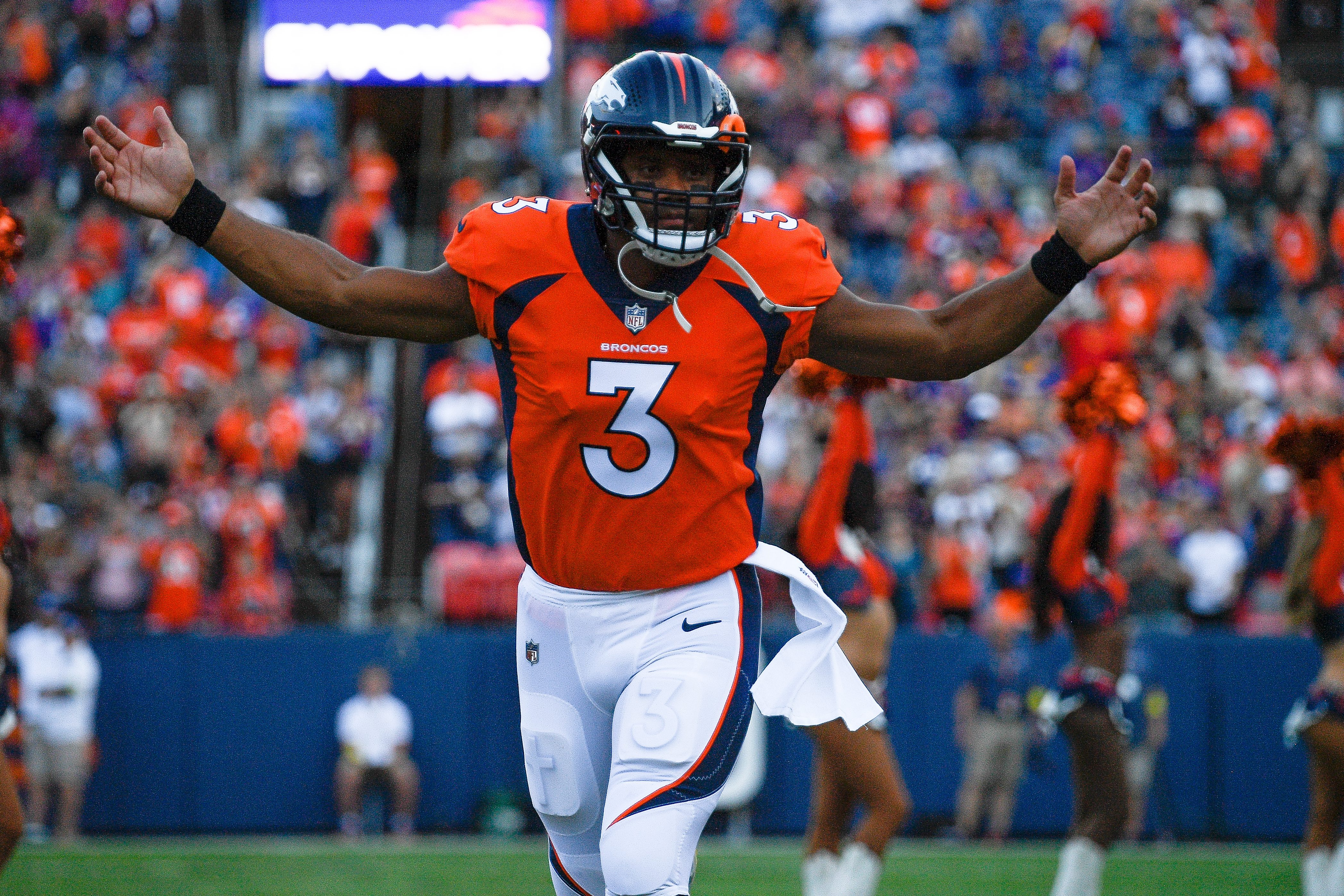 Denver Broncos quarterback Russell Wilson runs onto the field before a preseason game against the Minnesota Vikings.