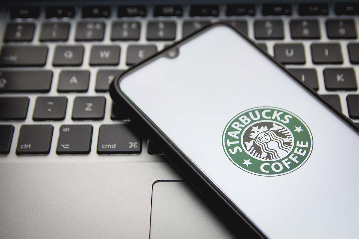 A photo illustration of a Starbucks logo seen displayed on a smartphone screen. Starbucks is introducing a web3-based loyalty program called Odyssey.