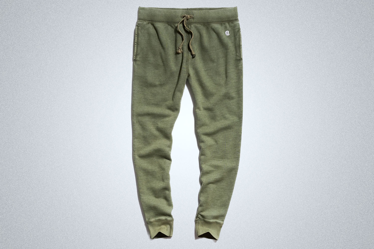 a pair of green Todd Snyder joggers on a grey background