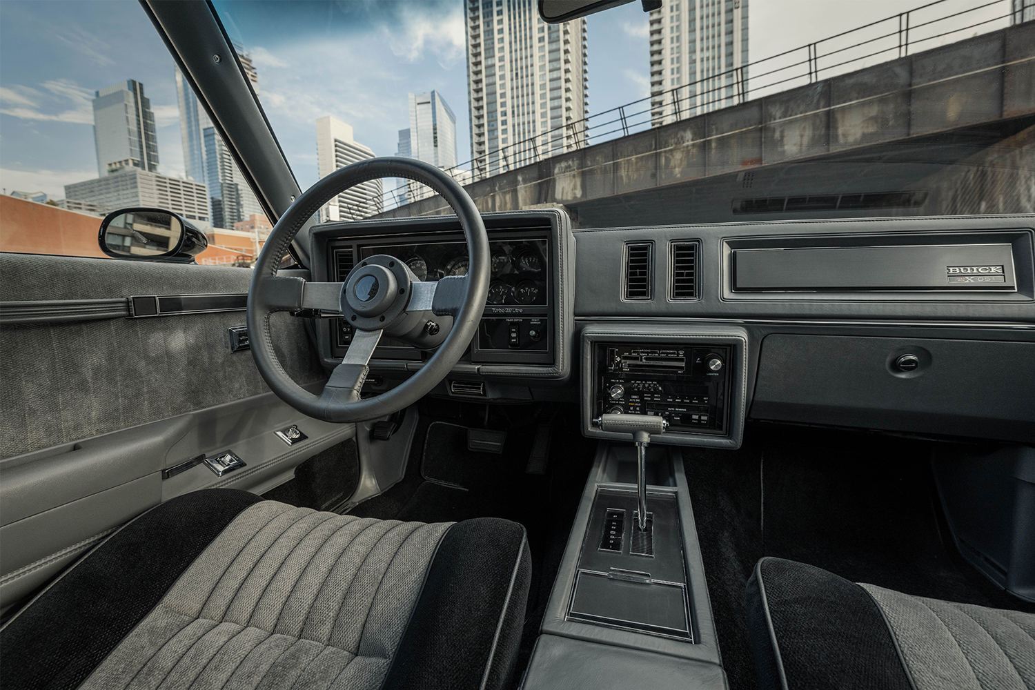 The retro black and grey interior of a 1987 Buick Grand National GNX muscle car