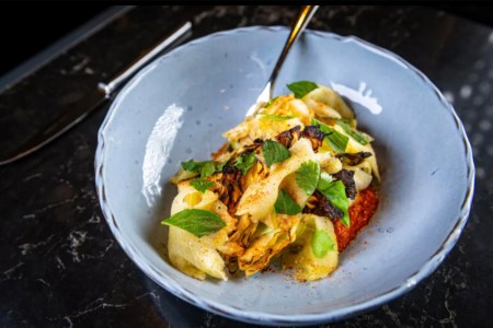 Old Bay Blackened Savoy Cabbage with Peanut Romesco, Shaved Compressed Pineapple, and Herbs