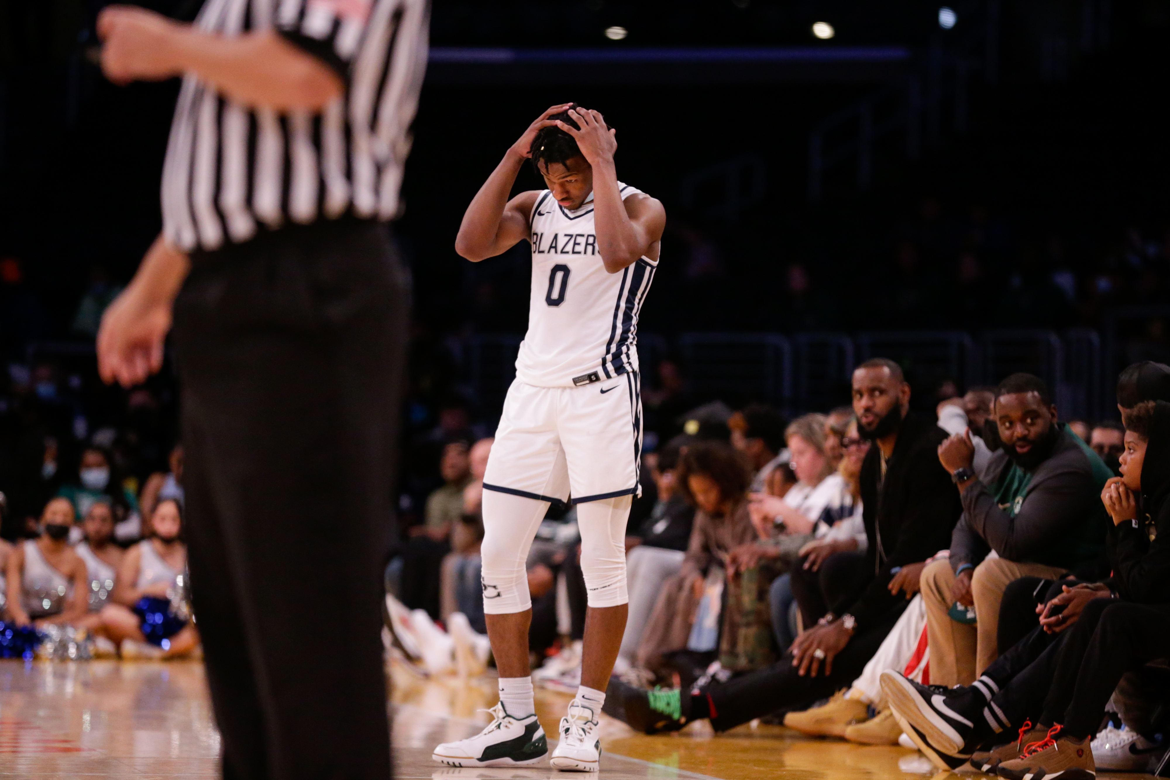 Bronny James playing basketball as father LeBron looks on