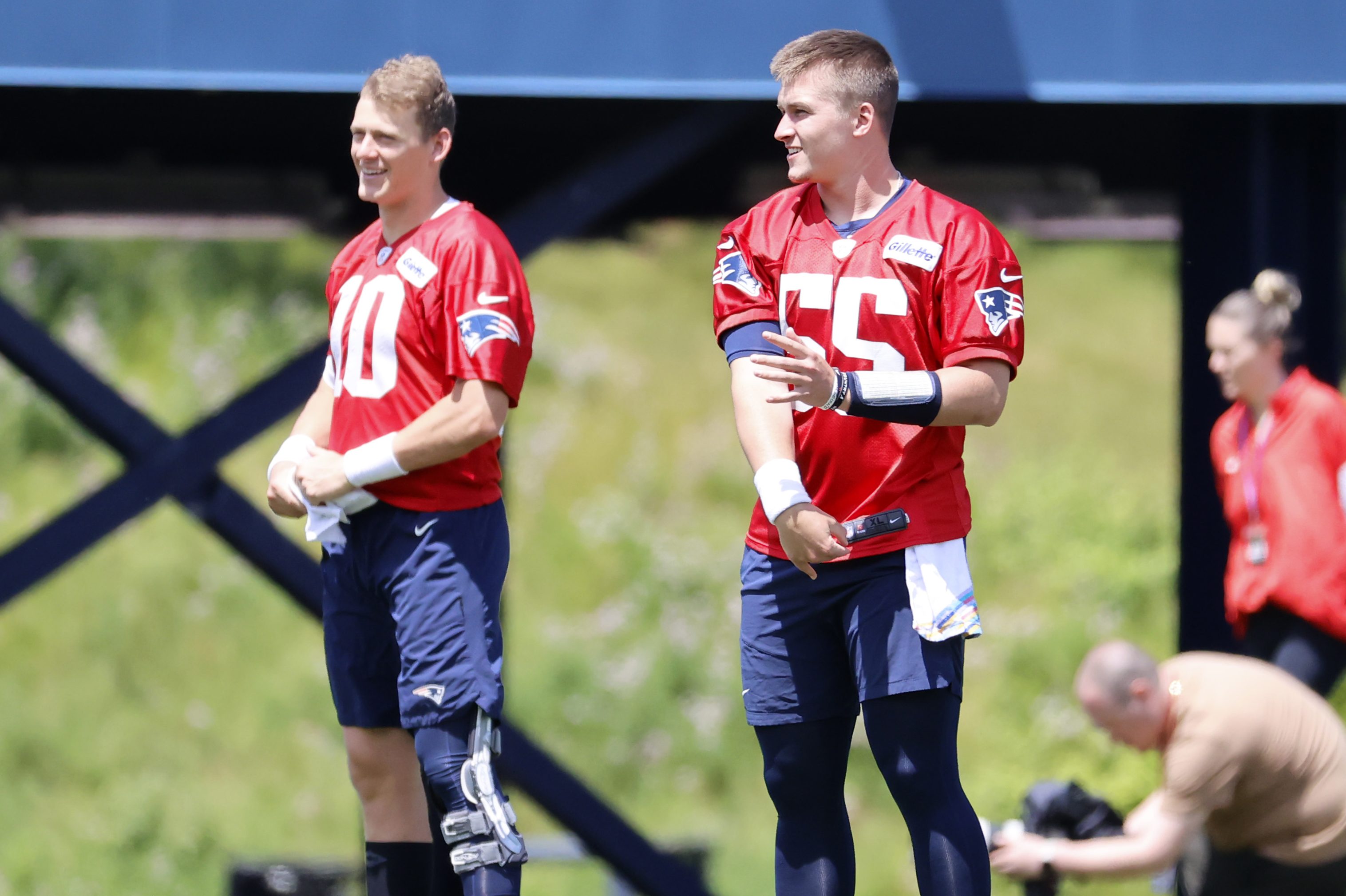 Patriots quarterbacks Mac Jones (10) and Bailey Zappe (55) warm up at minicamp.