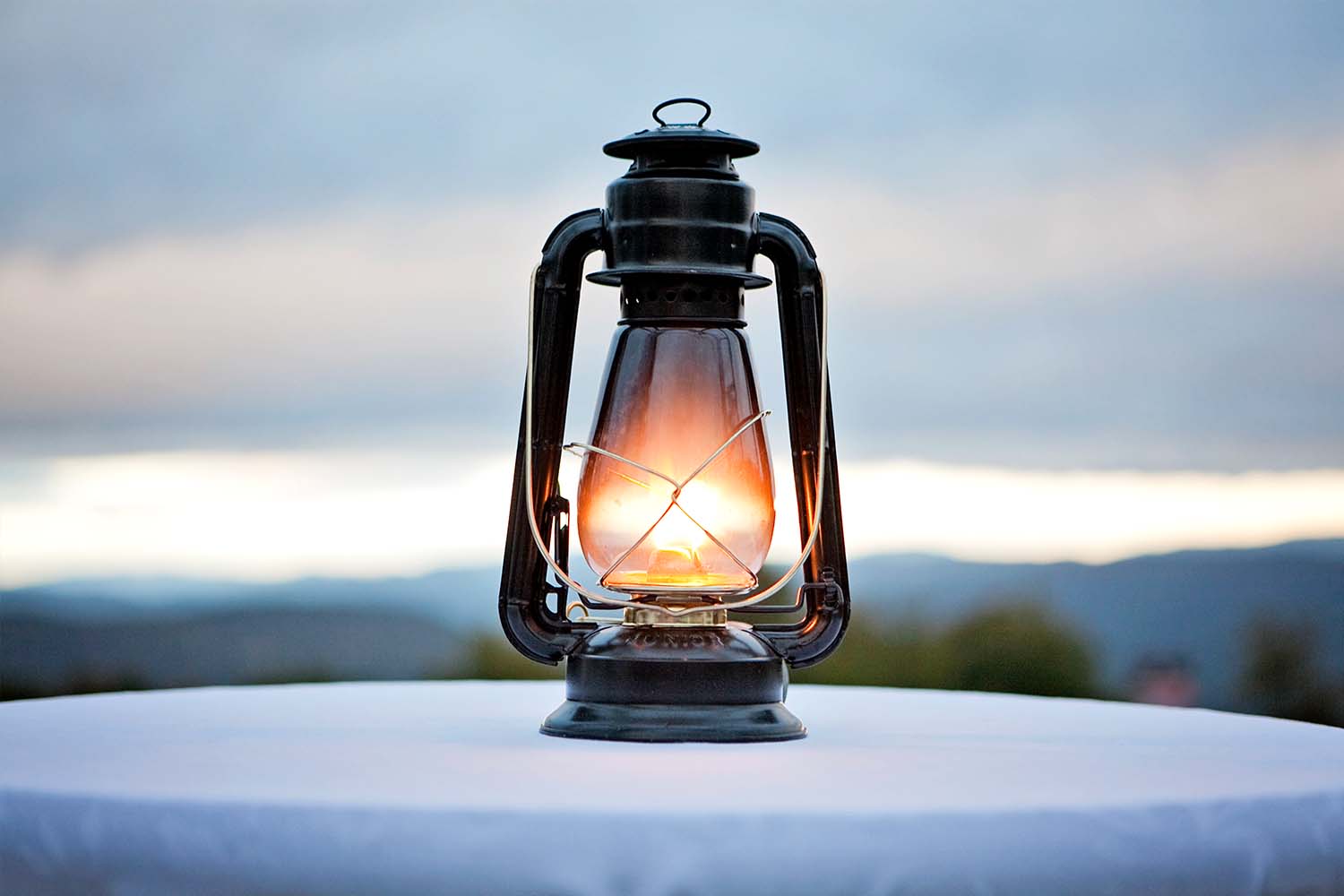 An antique gas lantern sits on a tabletop in the fading twilight. "Gaslighting" is Merriam-Webster's word of the year for 2022.