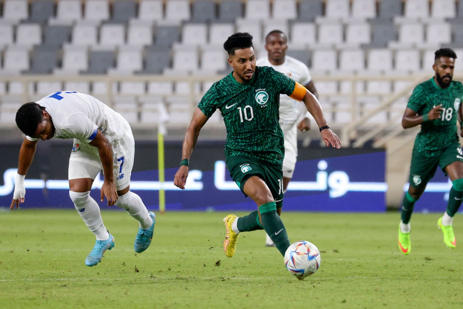 a soccer player in a patterned green soccer jersey.