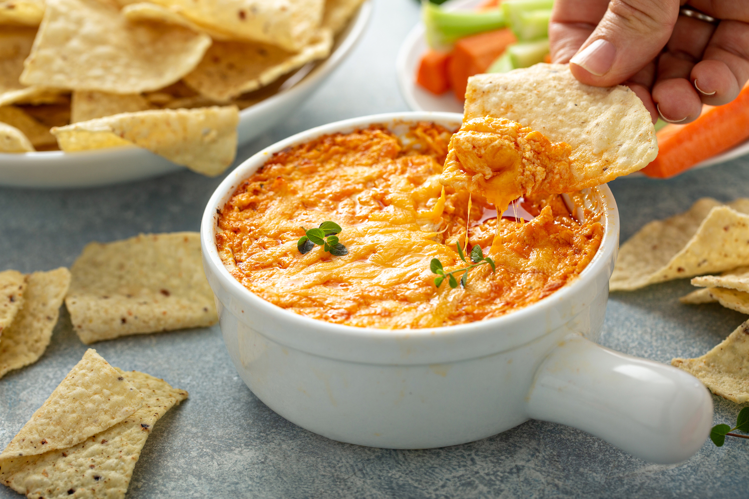 Buffalo leftover turkey dip in a white crock with chips