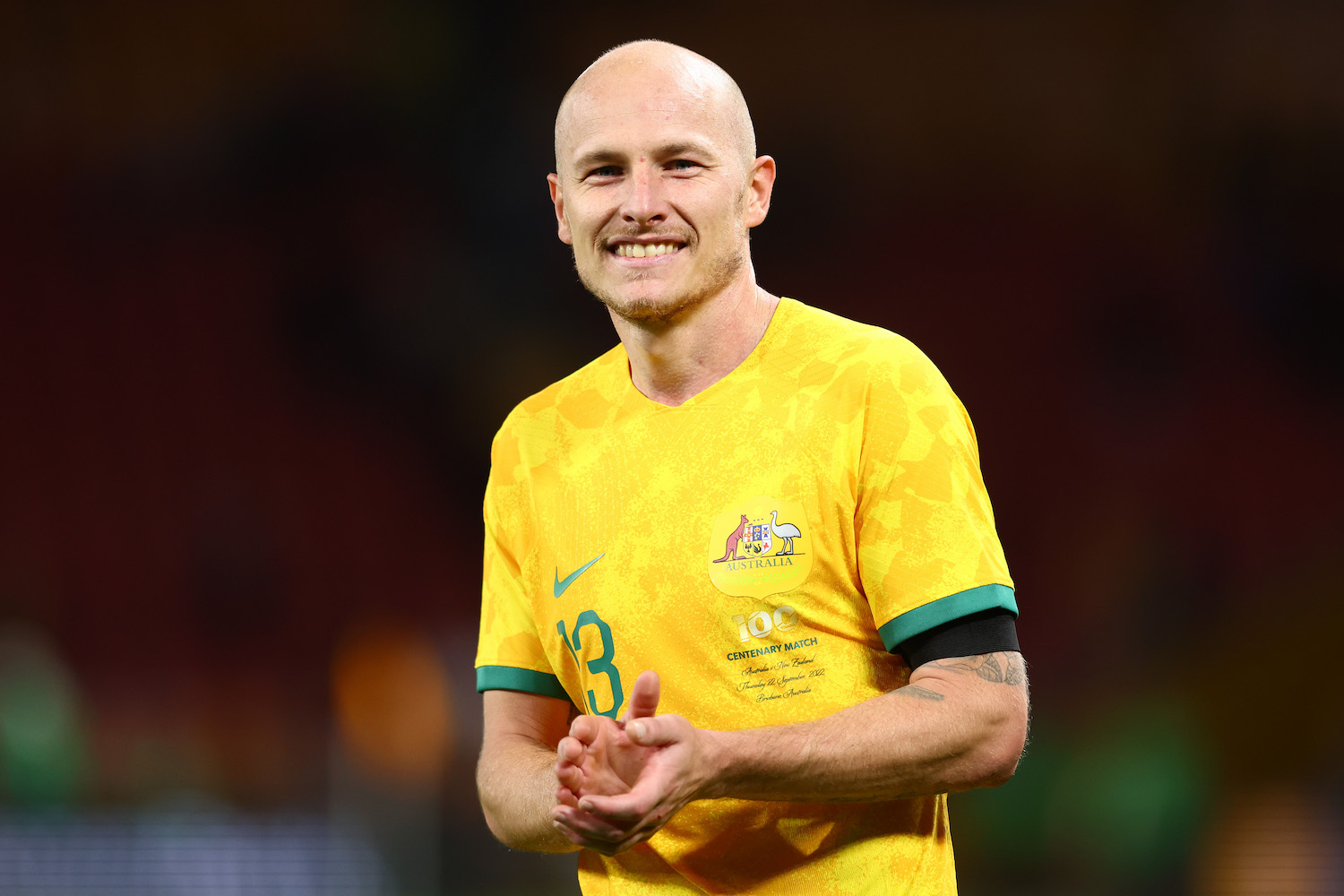 a australian soccer player in a yellow soccer jersey