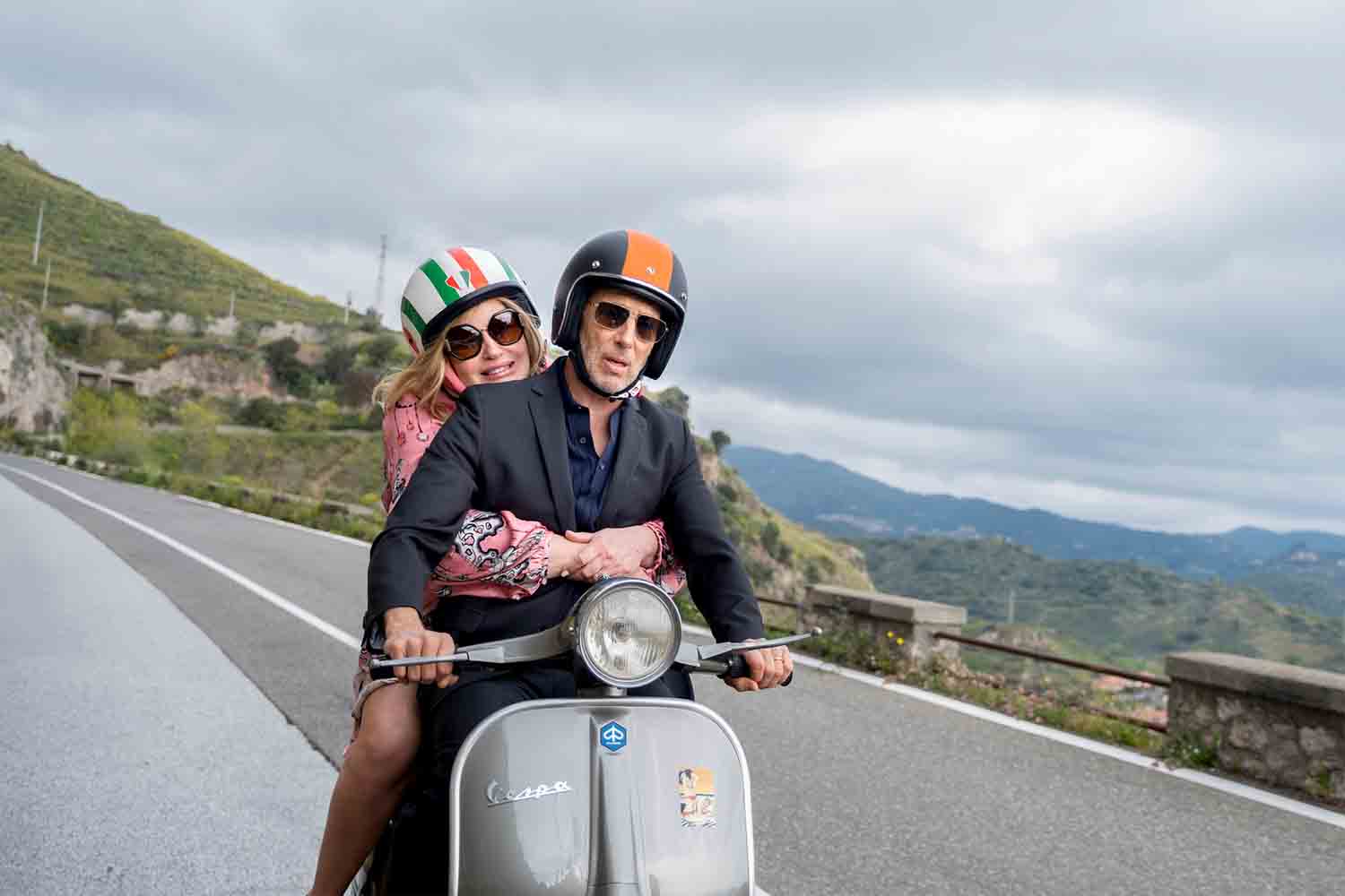 Two white lotus stars on a vespa on a mountain