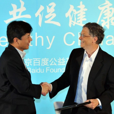 Robin Li and Bill Gates shaking hands at a conference.