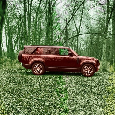 A maroon Land Rover in the woods in fall with lots of leaves