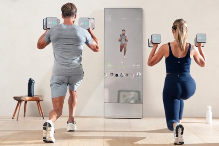 A man and woman working out with the Lululemon Studio Mirror, which is currently 50% off