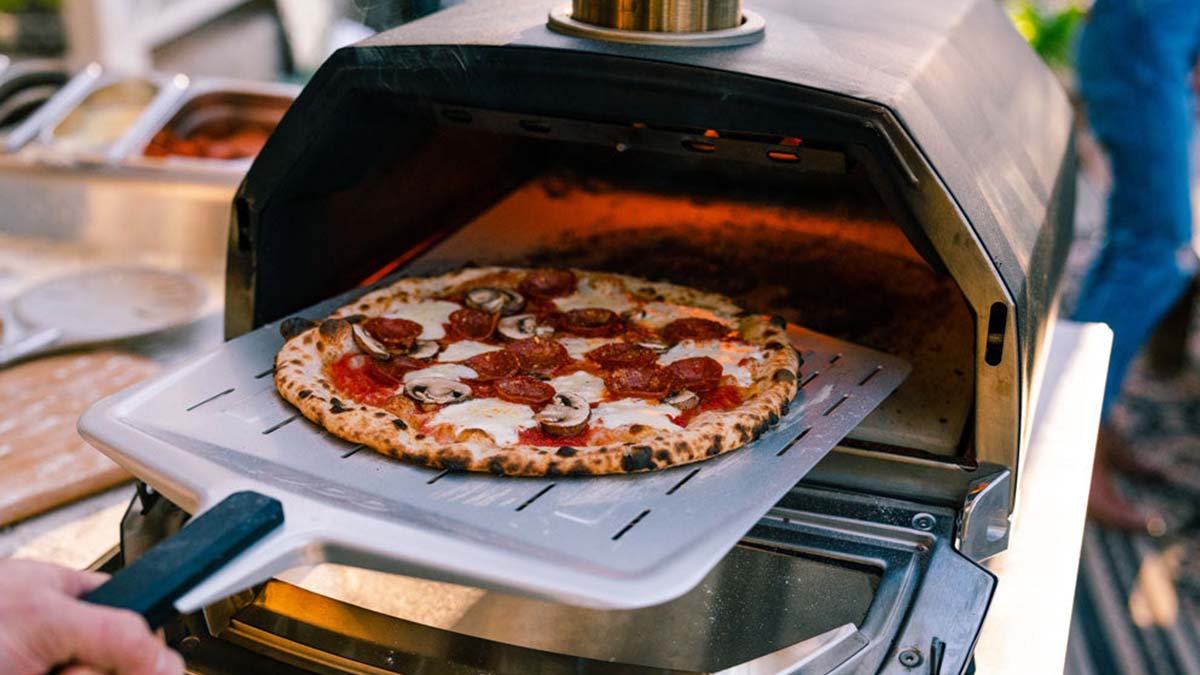 A pizza going into the Ooni Karu 16 Multi-Fuel Pizza Oven, now on sale for Black Friday