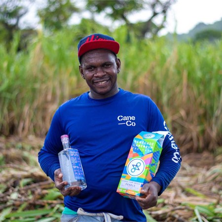 A worker holding a bottle of Renegade Rum in Grenada. The rum brand has made a large investment into the island with its new distillery.