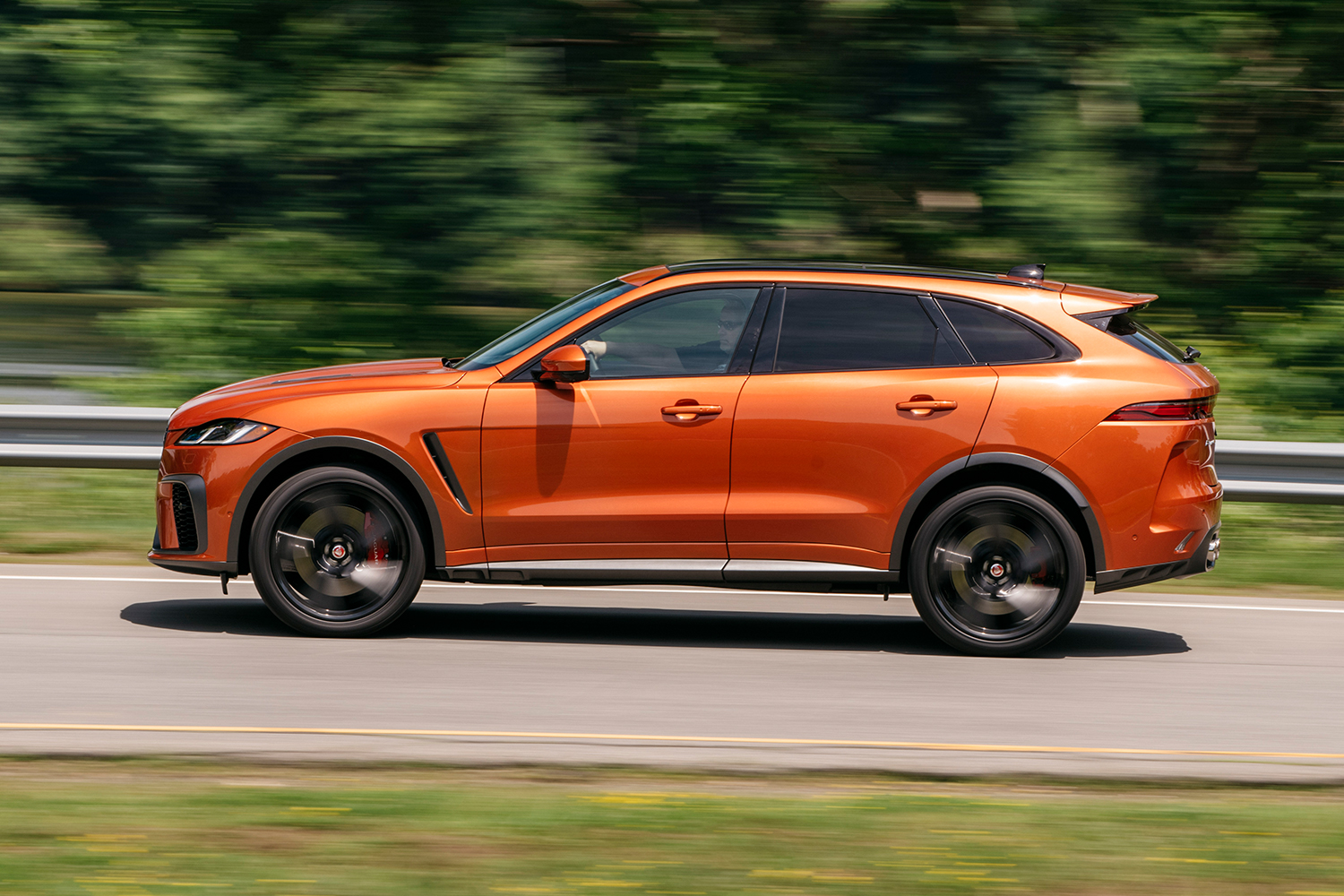 The Jaguar F-Pace SVR SUV in Atacama Orange drives on a road in the U.S.