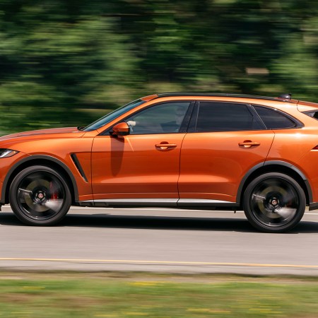 The Jaguar F-Pace SVR SUV in Atacama Orange drives on a road in the U.S.