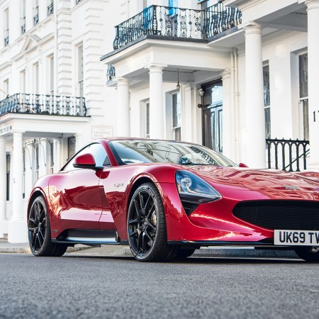 The TVR Griffith V8 sports car in red sitting in front of a British Union Jack flag hanging in the background