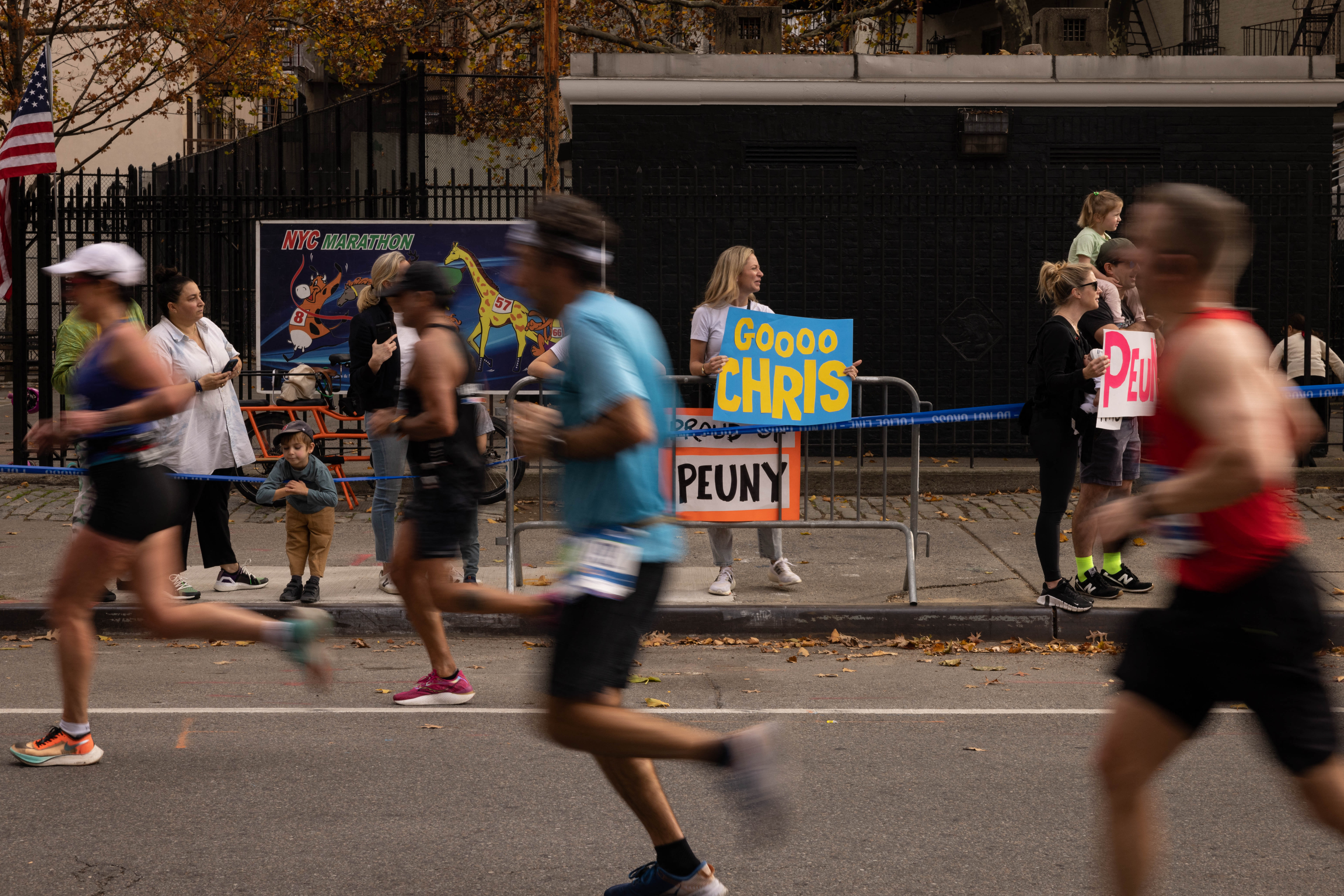 A woman holds a sign to cheer on runners at the New York City Marathon.