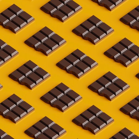 Seamless pattern of bitten chocolate bars on a yellow background