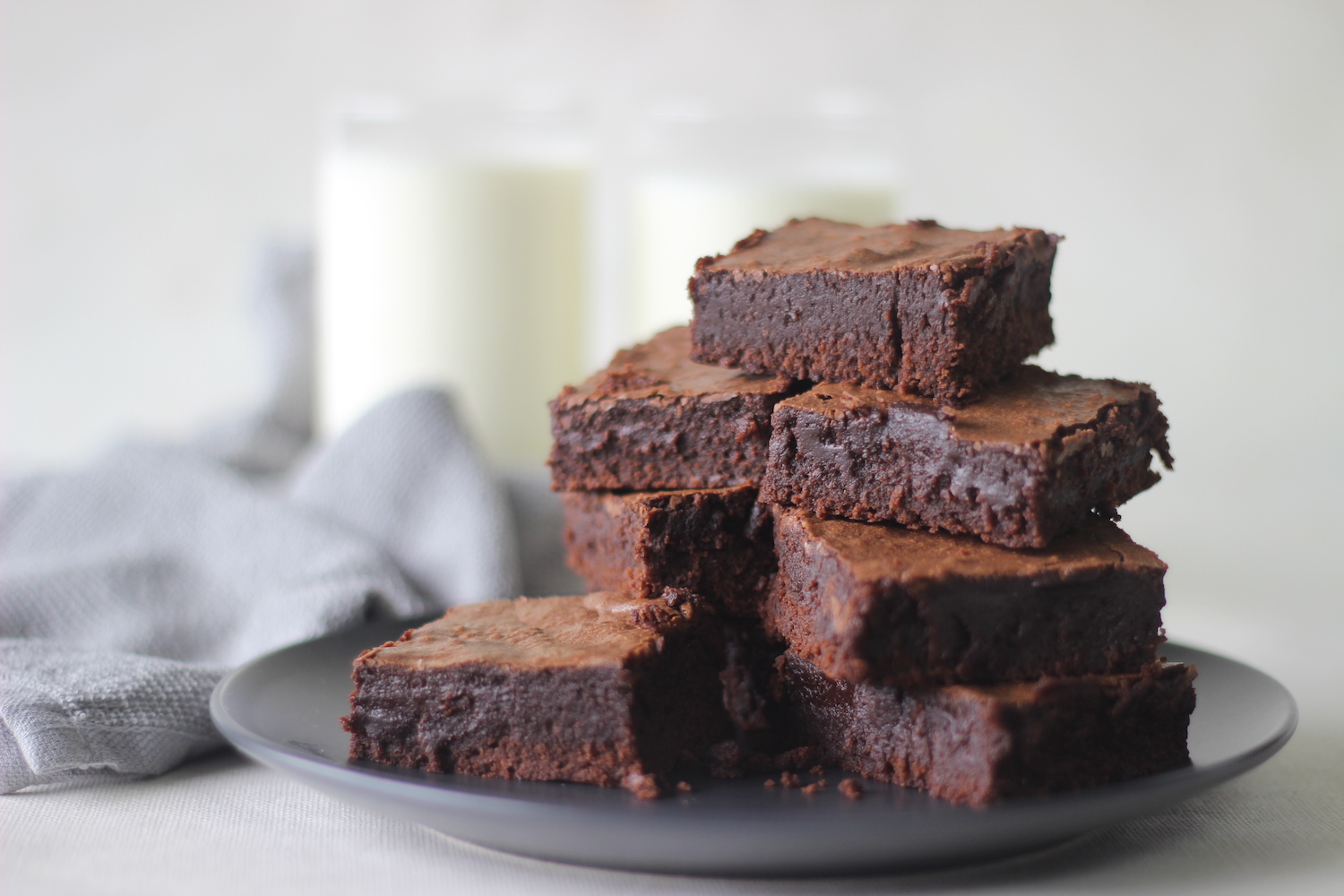 Home baked fudgy chocolate brownie sliced in square blocks and stacked one over the other