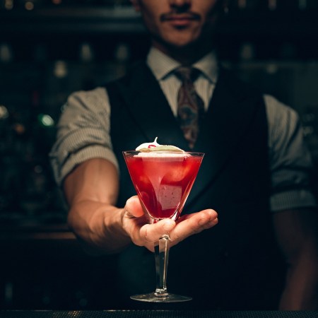 bartender at NR in new york city holding a red cocktail