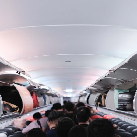 Passengers boarding an airplane with the baggage compartments open. A flight attendant explains why you should be the last person to board a plane.