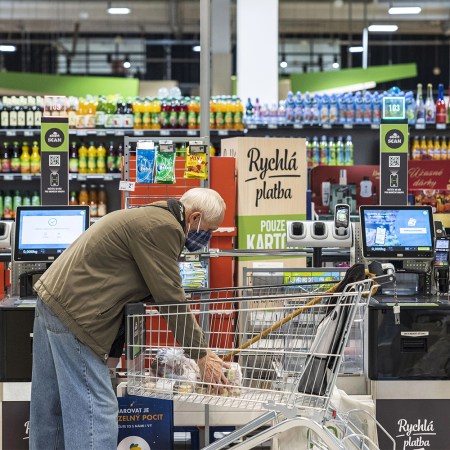 An elderly man in a self-checkout lane.