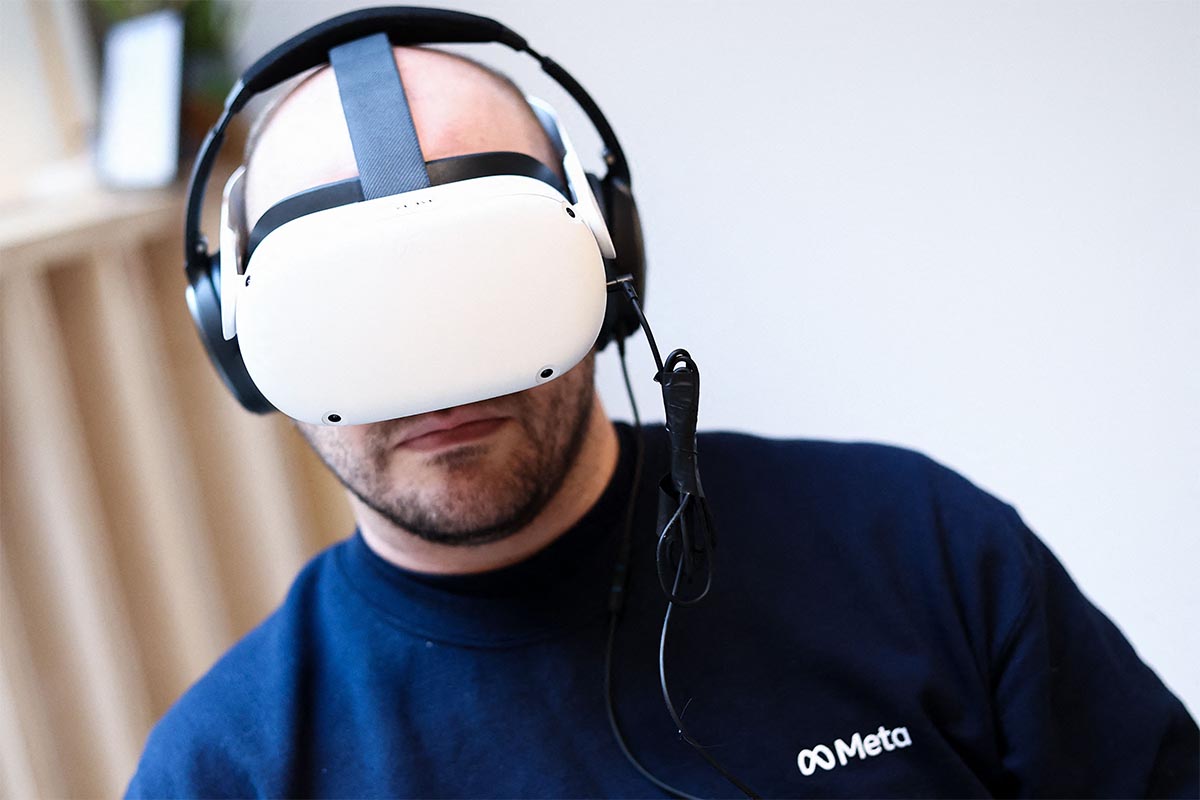 A Meta worker uses a Meta Quest VR headset at the Meta showroom in Brussels on December 07, 2022. Consumer sales of VR headsets were down in 2022, sparking concerns about interest in the metaverse.