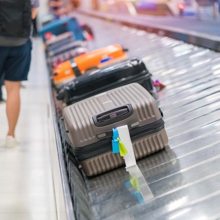 Luggage on a conveyor belt in an airport. If you're stuck waiting at a baggage carousel, you may be entitled to miles from your airline.