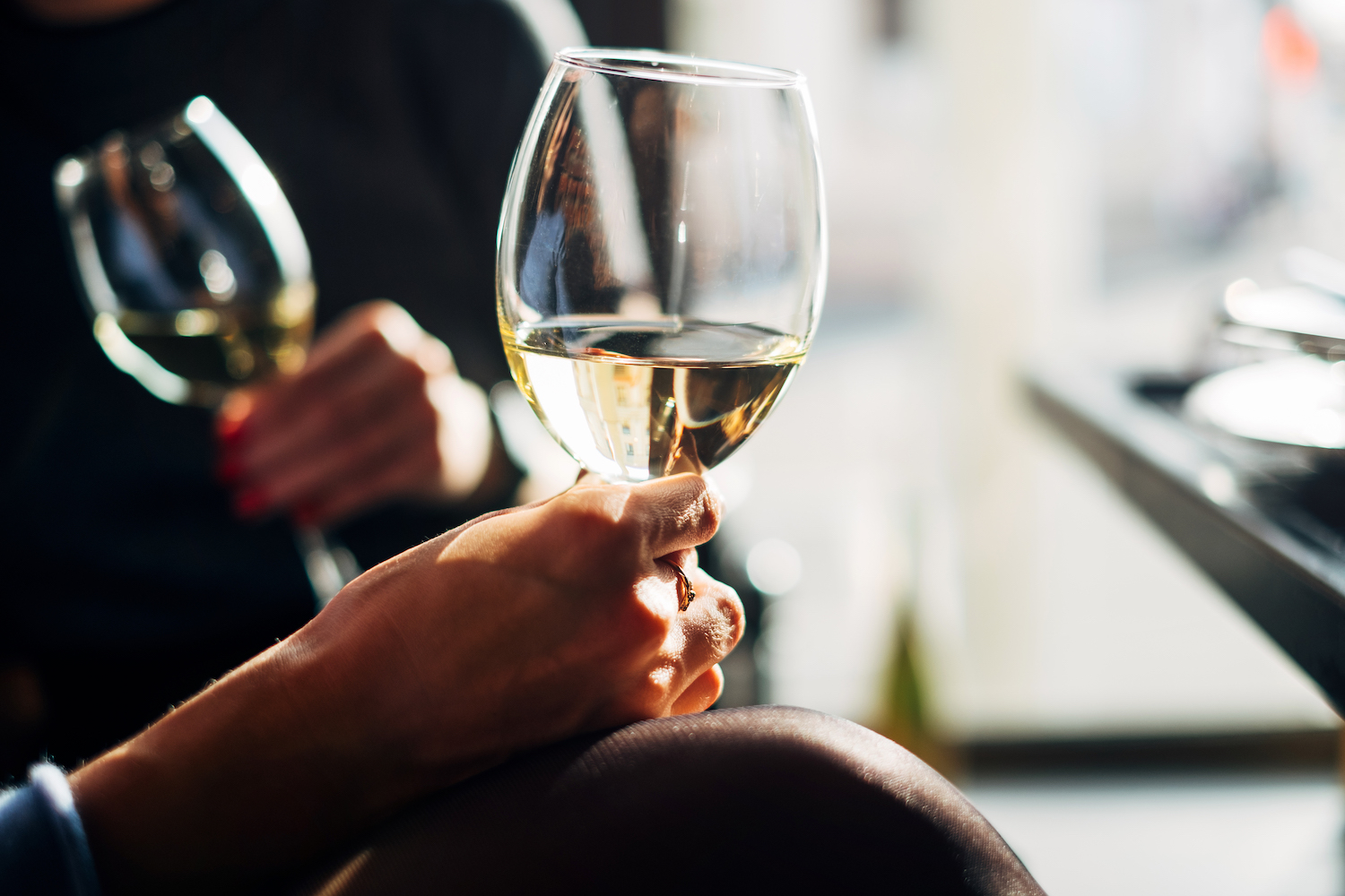 Two women sitting at a table enjoying a glass of white wine