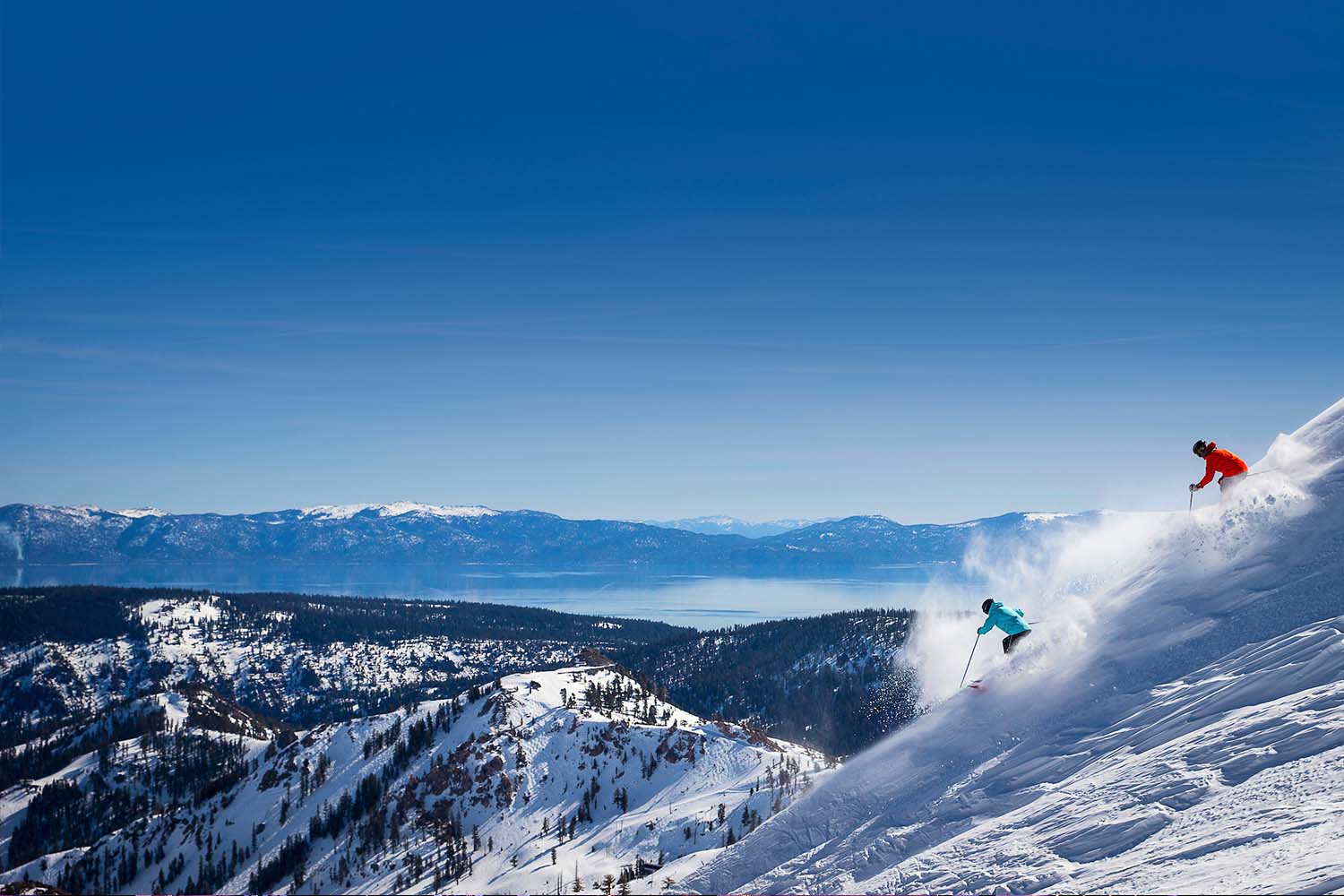 person downhill skiing against a blue sky in Palisades Tahoe