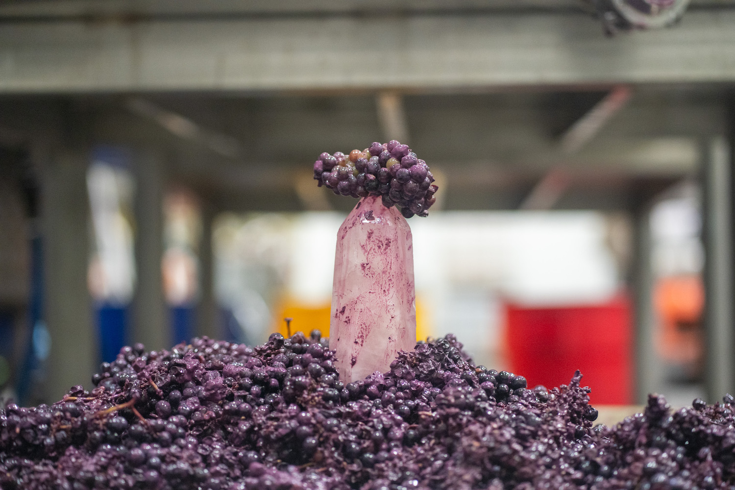 a quartz crystal sitting on a mound of red grapes at tank garage winery