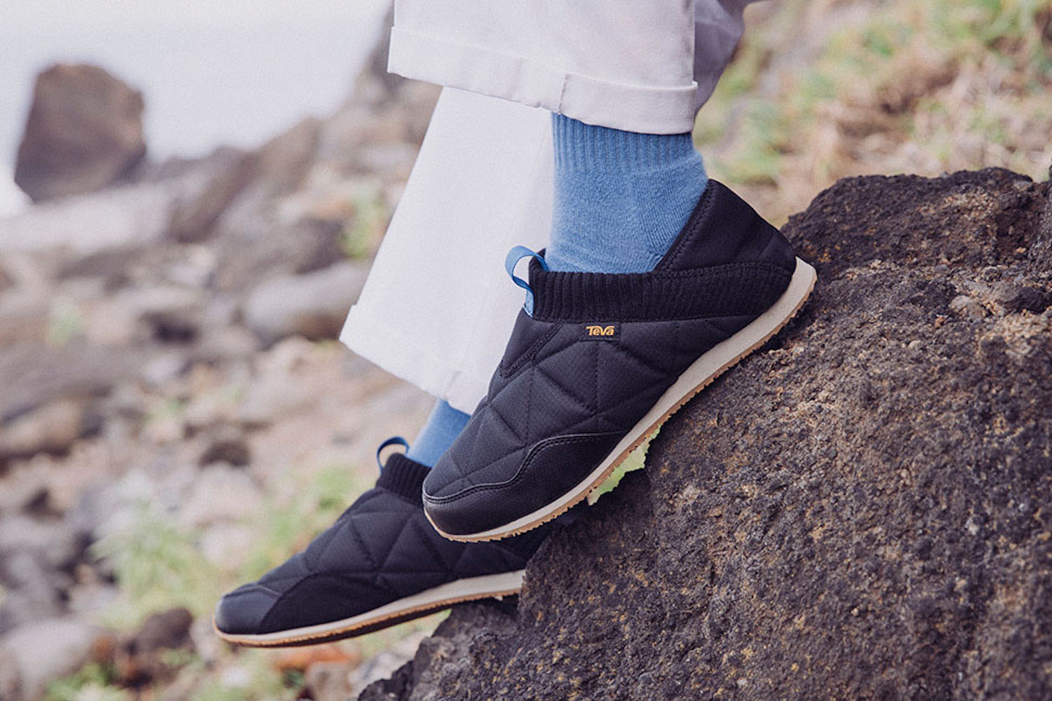 A model in a pair of black Teva ReEmber Mocs outside