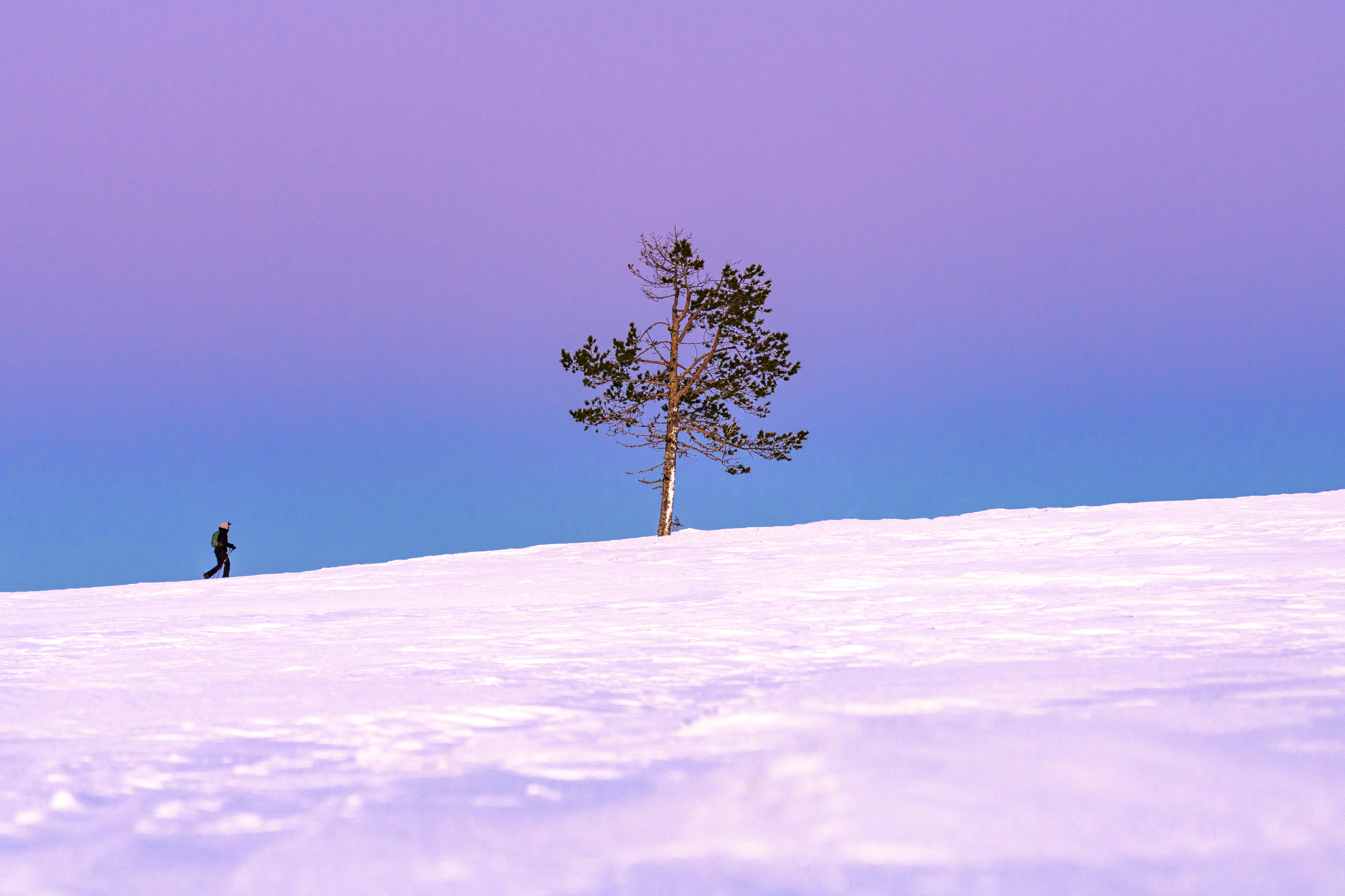 A woman snowshoeing in Finland at dusk.