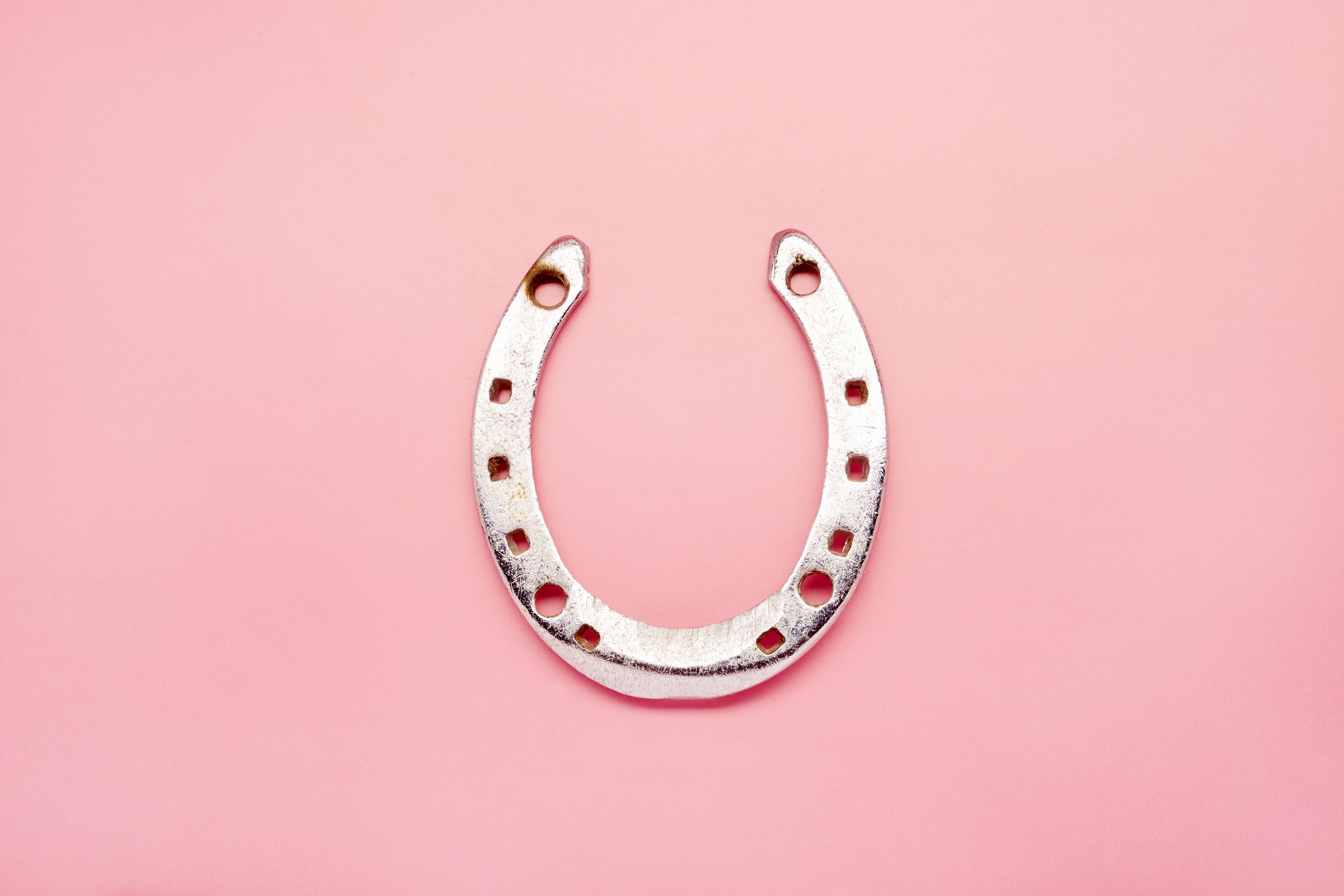 A horseshoe on a pink background.