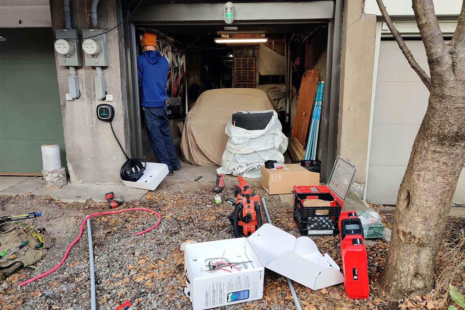 An electrician installing a Wallbox Pulsar Plus electric car charger in a home garage